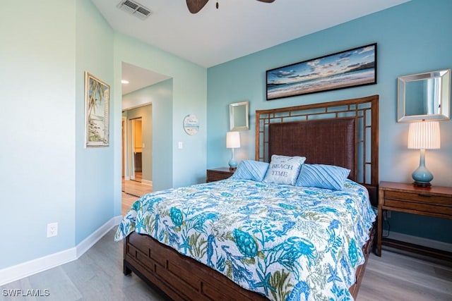 bedroom with ceiling fan, wood-type flooring, and ensuite bathroom