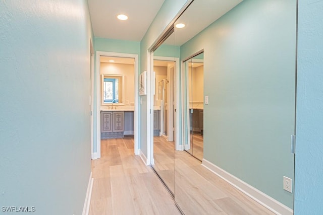 hall with sink and light hardwood / wood-style flooring