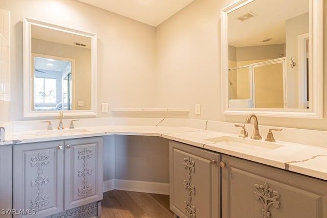 bathroom featuring a shower with shower door, hardwood / wood-style flooring, and vanity