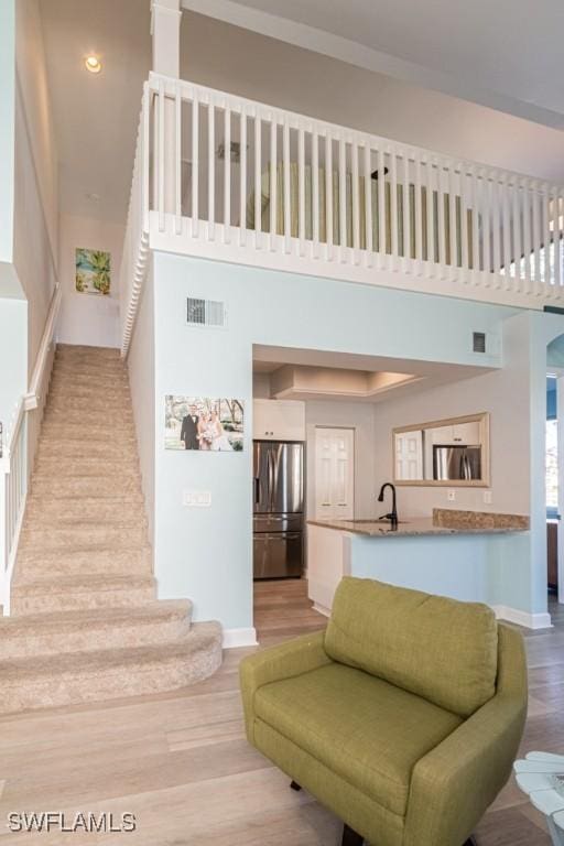 stairway featuring a towering ceiling and hardwood / wood-style floors