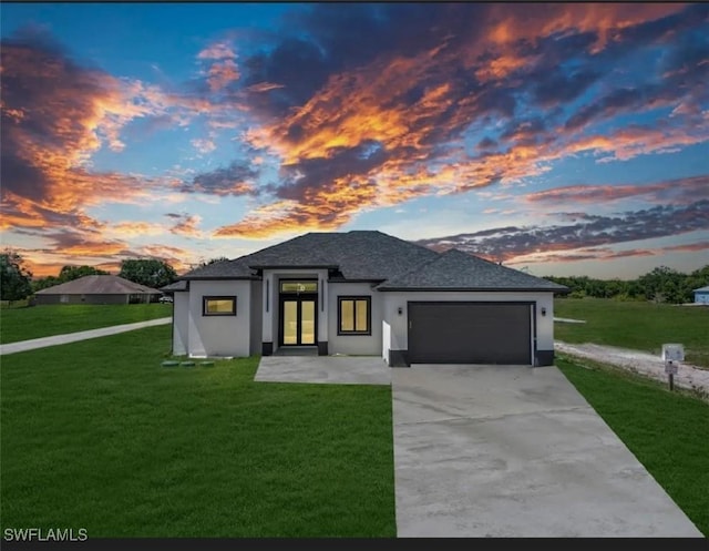 prairie-style house featuring a lawn and a garage