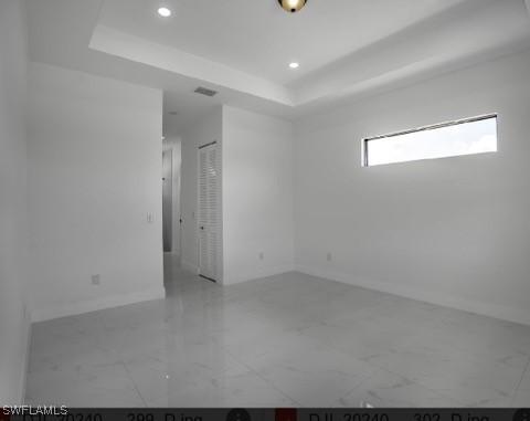 unfurnished room featuring a tray ceiling