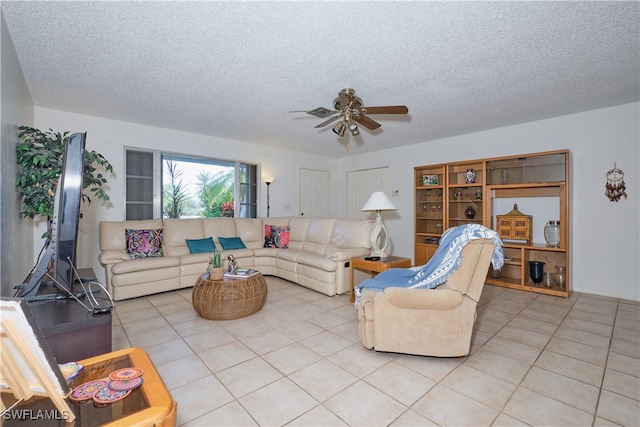 living room with ceiling fan, light tile patterned floors, and a textured ceiling