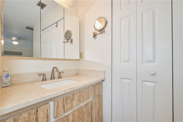 bathroom with vanity and a textured ceiling