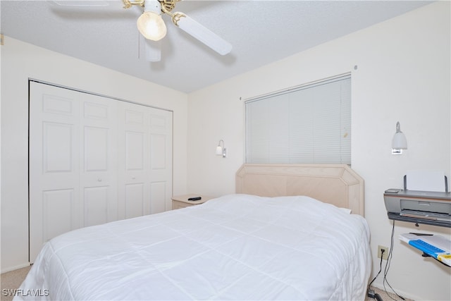 bedroom with a textured ceiling, a closet, ceiling fan, and carpet flooring