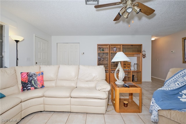 tiled living room with ceiling fan and a textured ceiling