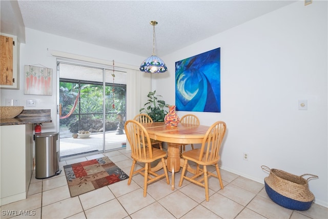 dining room with a textured ceiling and light tile patterned flooring