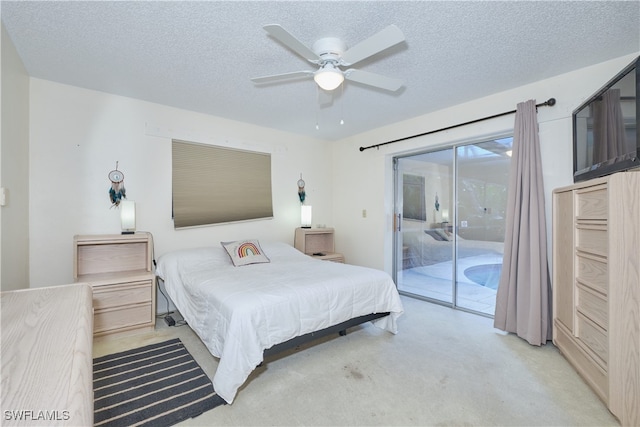 carpeted bedroom with ceiling fan, access to exterior, and a textured ceiling