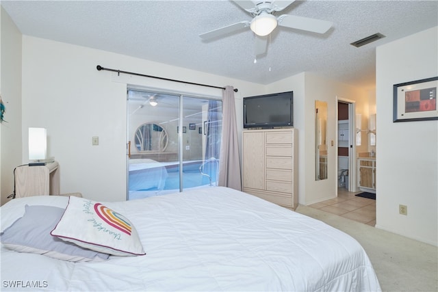 tiled bedroom featuring ceiling fan, ensuite bath, a textured ceiling, and access to outside