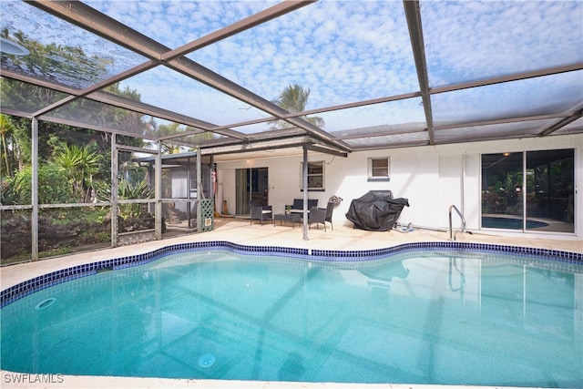 view of swimming pool with glass enclosure and a patio area