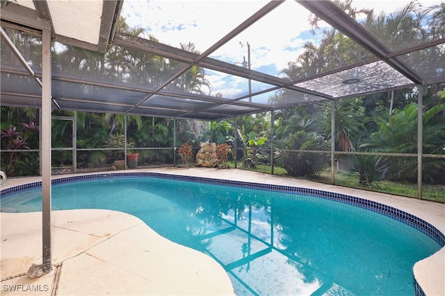 view of pool with a patio and glass enclosure