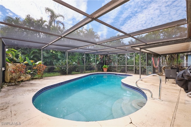 view of pool with glass enclosure and a patio