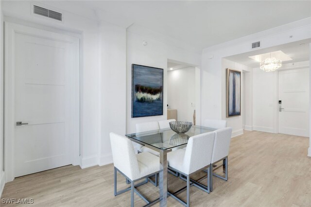 dining room with a chandelier and light hardwood / wood-style flooring