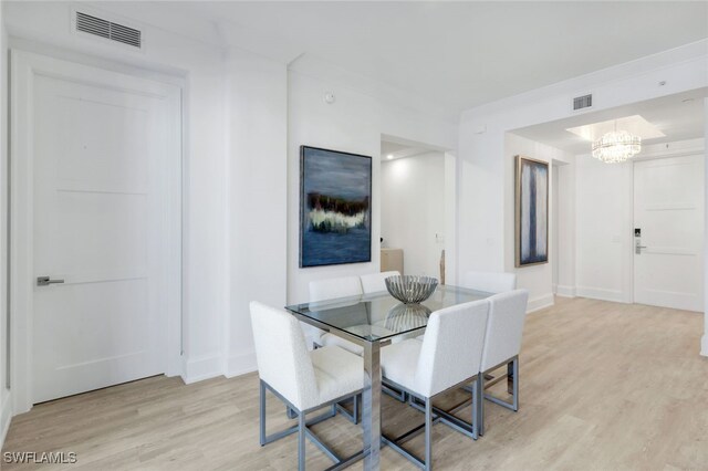 1030 3rd Ave S Unit 419, Naples, FL 34102 - dining room with light wood-style flooring, a chandelier, and baseboards