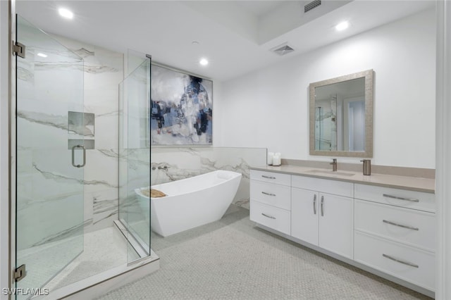 bathroom featuring plus walk in shower, tile patterned flooring, and vanity