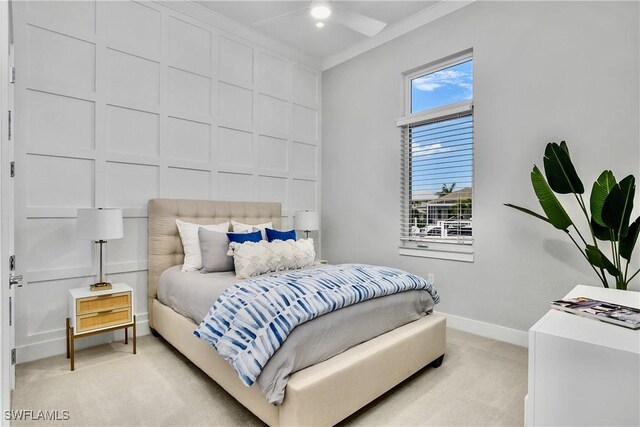 carpeted bedroom with ceiling fan and ornamental molding