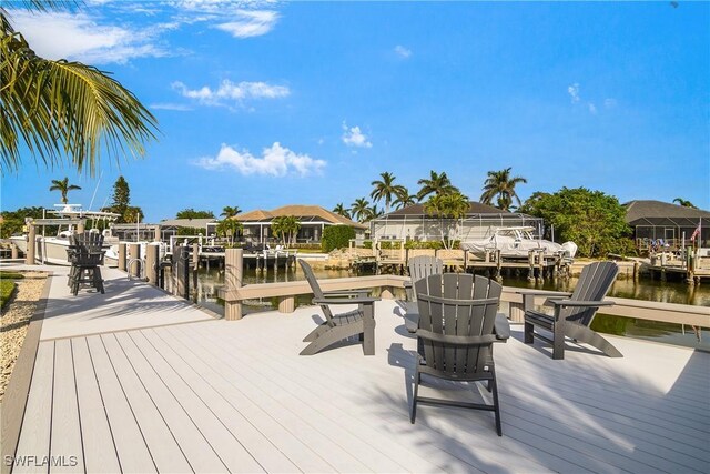 wooden terrace with a water view and a boat dock