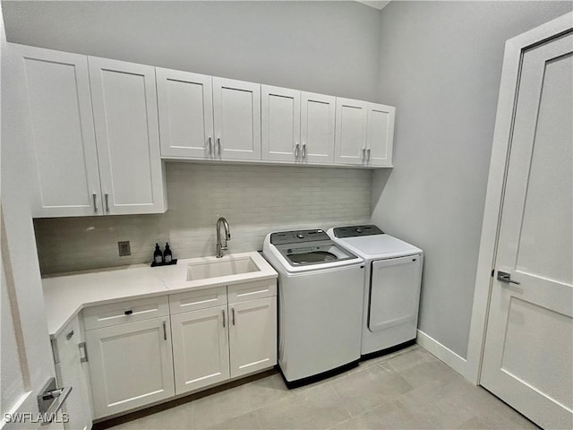 washroom with sink, cabinets, light tile patterned floors, and separate washer and dryer