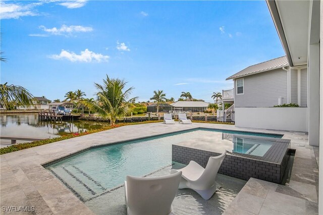 view of swimming pool with a hot tub, a water view, and a patio