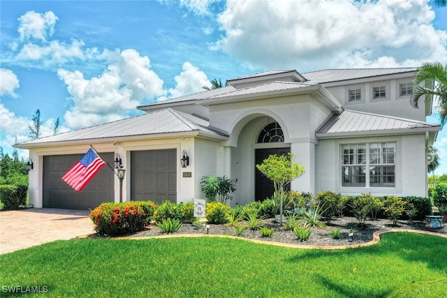 view of front of property with a garage and a front lawn