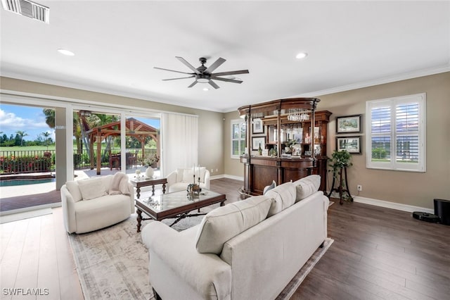 living room with ceiling fan, a healthy amount of sunlight, and dark wood-type flooring