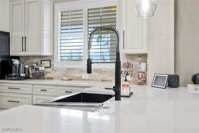 kitchen with hanging light fixtures, white cabinetry, and tasteful backsplash