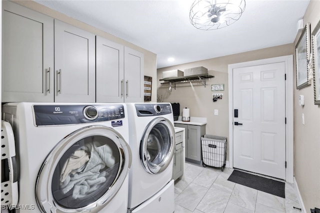 washroom with washing machine and dryer and cabinets