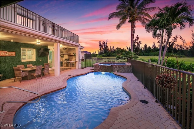 view of pool featuring a patio, pool water feature, and an in ground hot tub