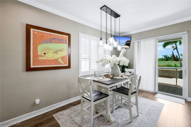 dining space with ornamental molding and hardwood / wood-style flooring