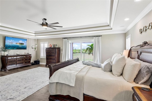 bedroom with access to outside, dark hardwood / wood-style floors, a raised ceiling, crown molding, and ceiling fan