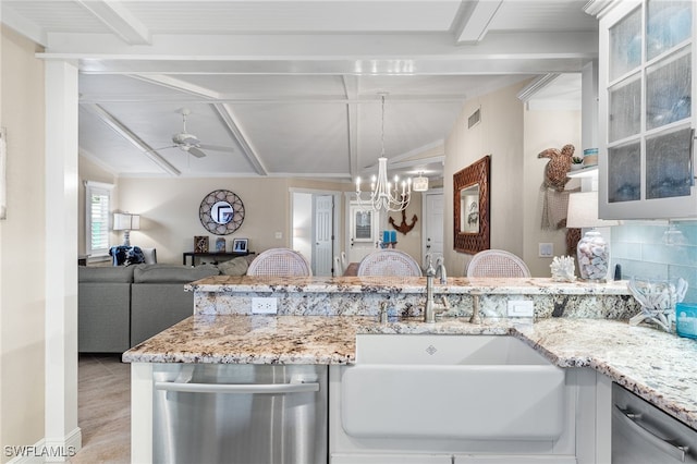 kitchen with sink, ceiling fan with notable chandelier, white cabinets, light stone counters, and lofted ceiling with beams