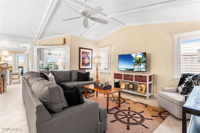 living room with ceiling fan, light tile patterned floors, lofted ceiling with beams, and a wealth of natural light