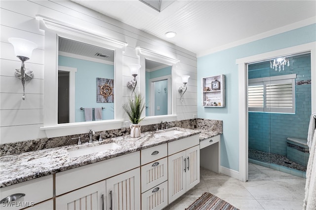 bathroom with tile patterned floors, ornamental molding, tiled shower, and vanity