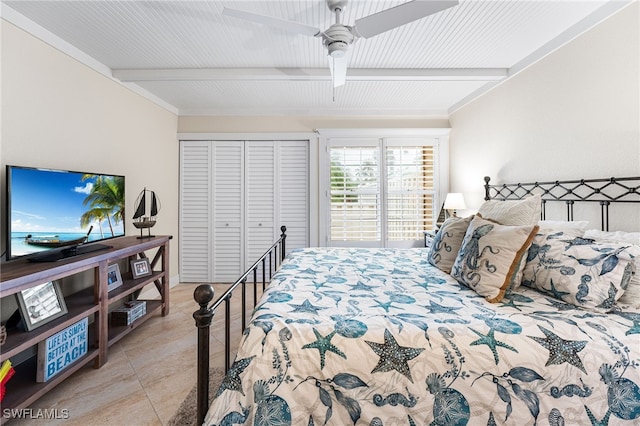 tiled bedroom featuring ceiling fan, a closet, and beam ceiling