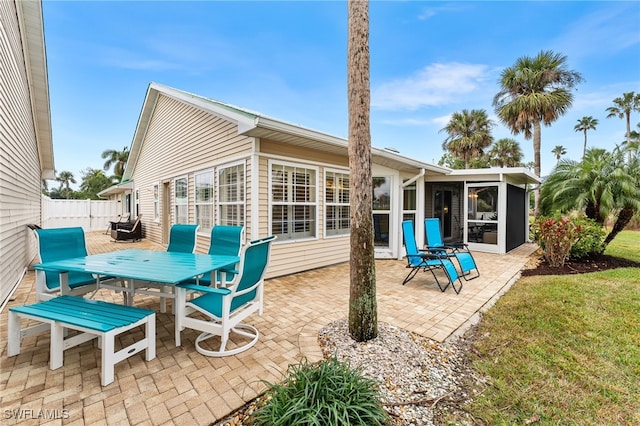 back of house with a patio area, a sunroom, and a yard