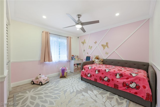 bedroom with hardwood / wood-style flooring, ceiling fan, and ornamental molding