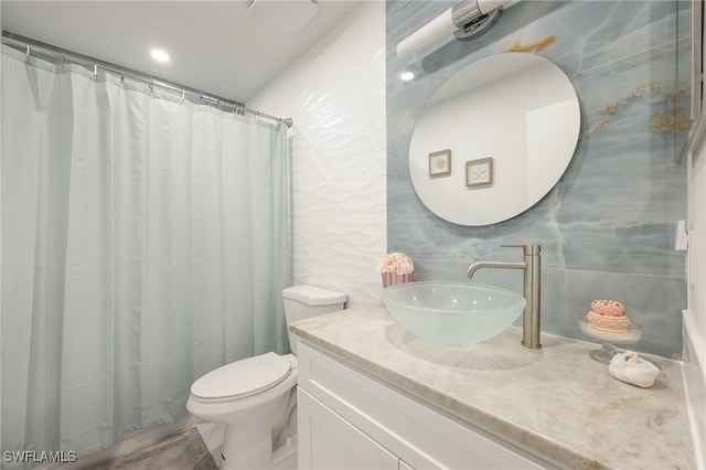 bathroom featuring toilet, vanity, tile walls, and curtained shower