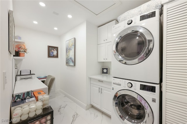 washroom featuring stacked washing maching and dryer and cabinets