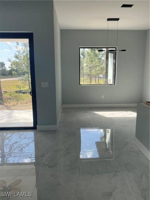 unfurnished dining area with marble finish floor, baseboards, and visible vents