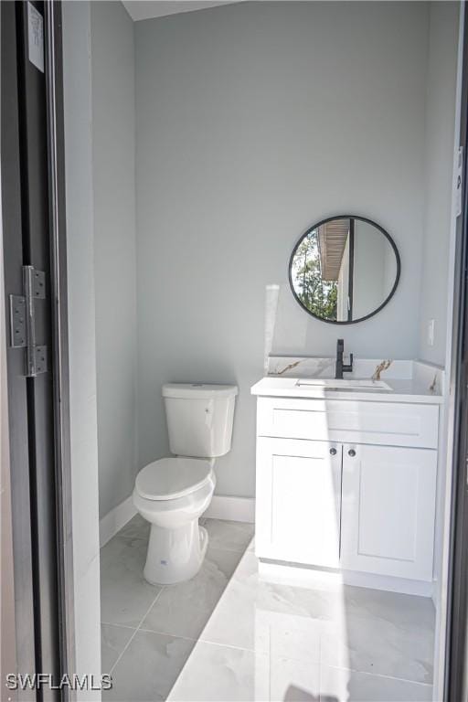 1254 Ellipse St E, Lehigh Acres, FL 33974 - half bathroom featuring toilet, baseboards, marble finish floor, and vanity