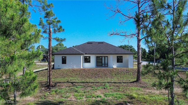 1254 Ellipse St E, Lehigh Acres, FL 33974 - back of property featuring roof with shingles and stucco siding