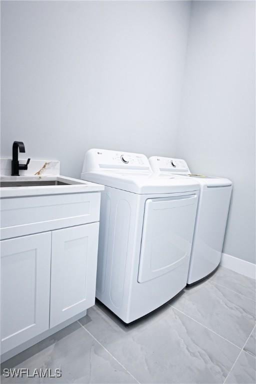 1254 Ellipse St E, Lehigh Acres, FL 33974 - laundry area featuring washer and dryer, a sink, marble finish floor, and cabinet space