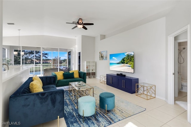 tiled living room featuring lofted ceiling and ceiling fan with notable chandelier