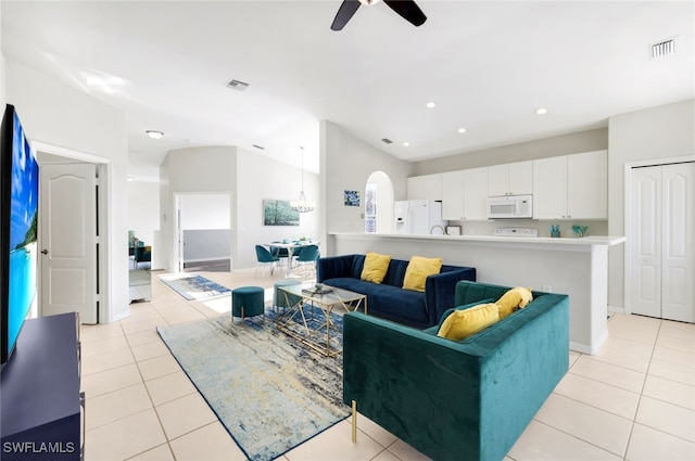 tiled living room with lofted ceiling and ceiling fan