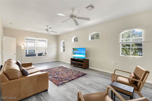 living room featuring wood-type flooring, a wealth of natural light, and ceiling fan