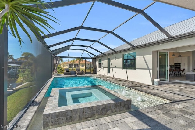 view of swimming pool with an in ground hot tub, glass enclosure, and a patio