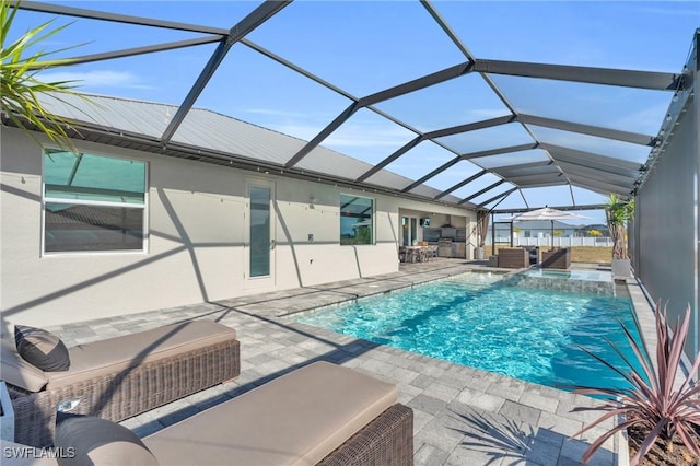 view of swimming pool featuring pool water feature, a patio, an outdoor hangout area, and glass enclosure