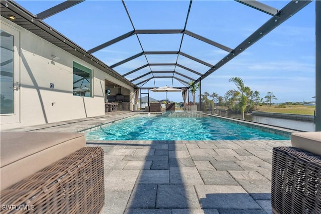 view of pool with pool water feature, a water view, glass enclosure, a bar, and a patio