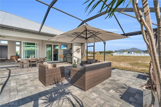 view of patio with ceiling fan, an outdoor living space, and a lanai