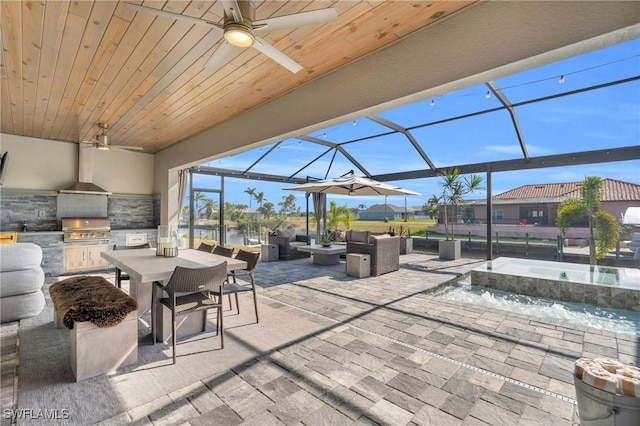 view of patio with pool water feature, area for grilling, a lanai, an outdoor living space, and exterior kitchen